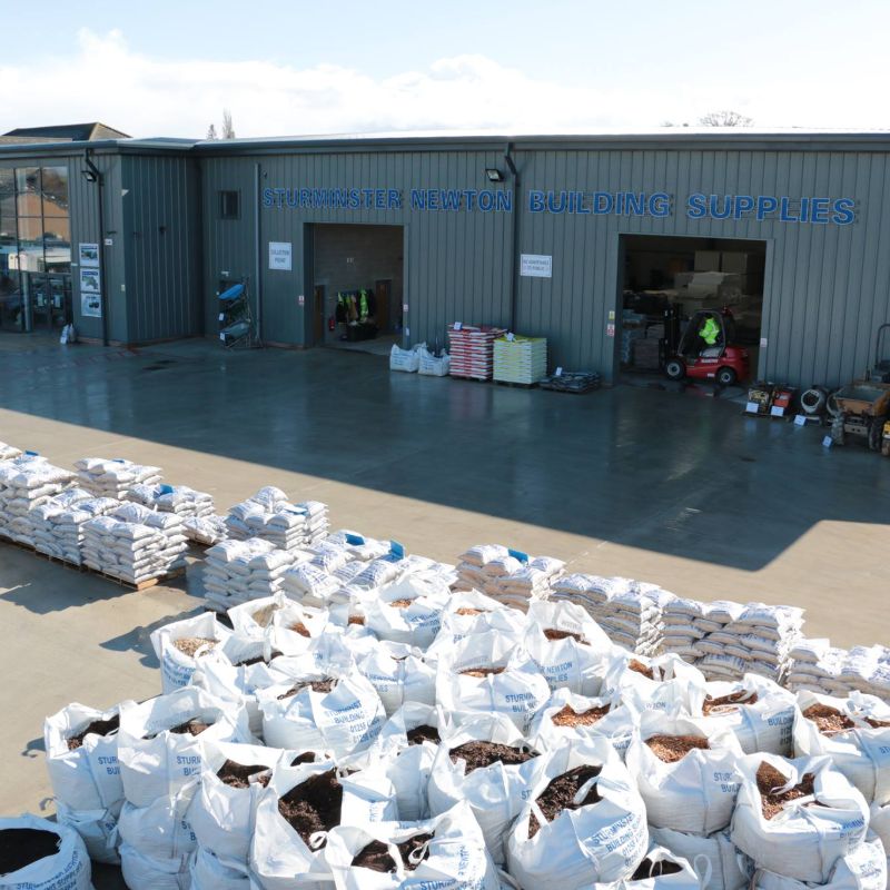 a view of a warehouse, forklift and big white bags